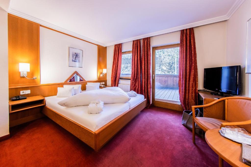 a hotel room with a bed and a television at Hundehotel Riederhof in Ried im Oberinntal