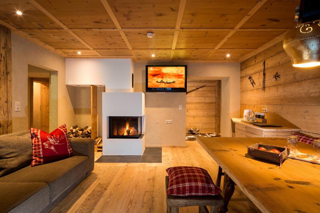 a living room with a couch and a fireplace at Hundehotel Riederhof in Ried im Oberinntal