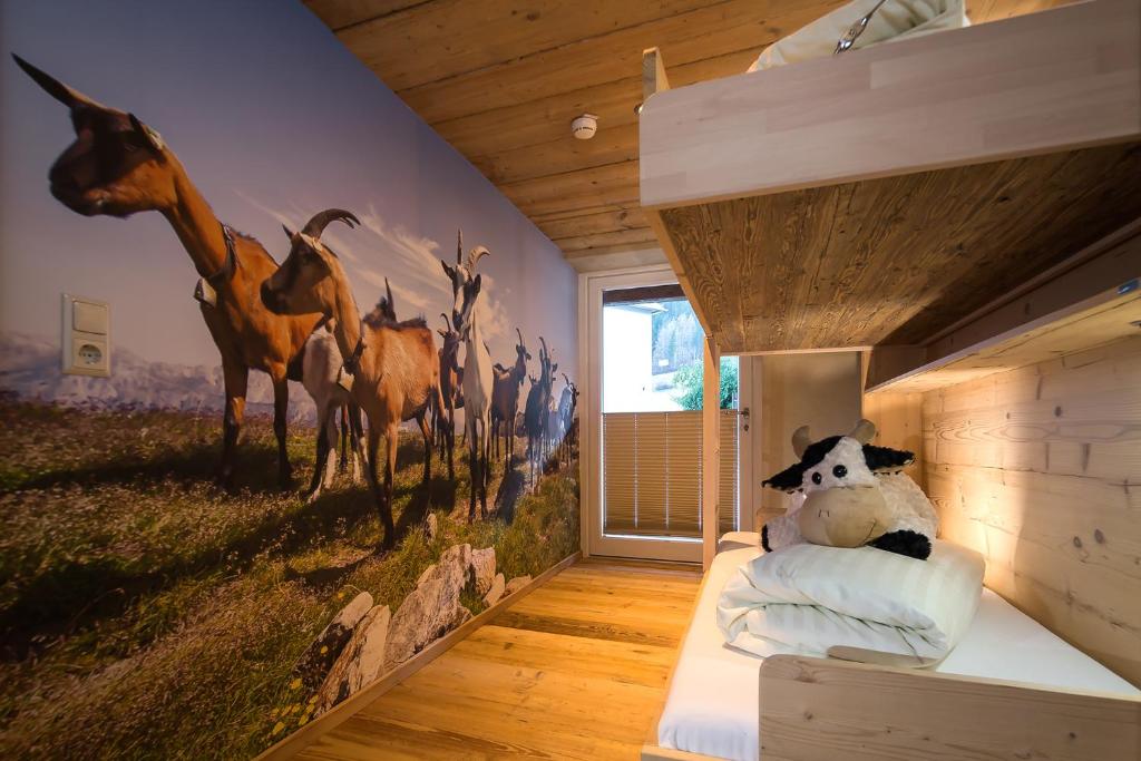 a bedroom with a mural of giraffes on the wall at Hundehotel Riederhof in Ried im Oberinntal