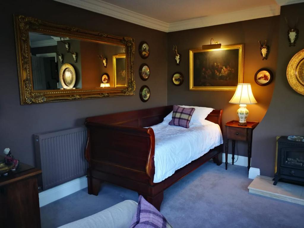 a bedroom with a bed and a mirror at Staggs Cottage in Andover