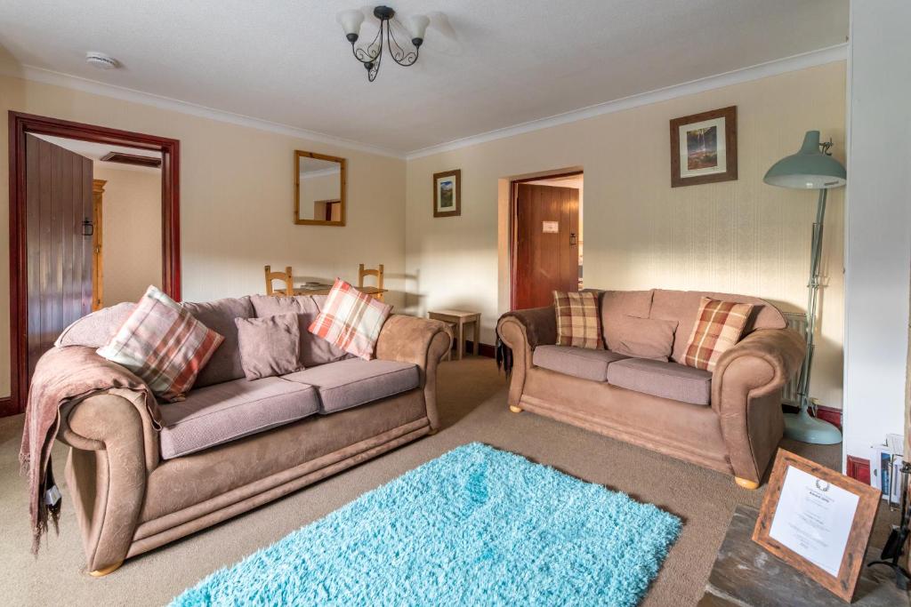 班堡的住宿－Host & Stay - Rose Cottage，客厅配有两张沙发和蓝色地毯。