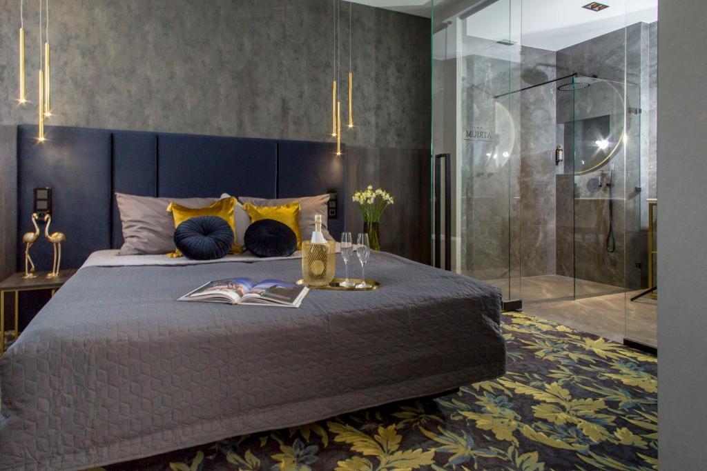 a bedroom with a large bed and a glass shower at Hotel Atrium in Kraków