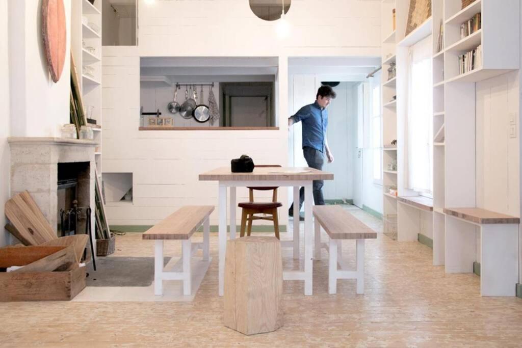 Logement Design à Loix-en-Ré - 2 étoiles - Centre Village في Loix: رجل يقف على طاولة في غرفة