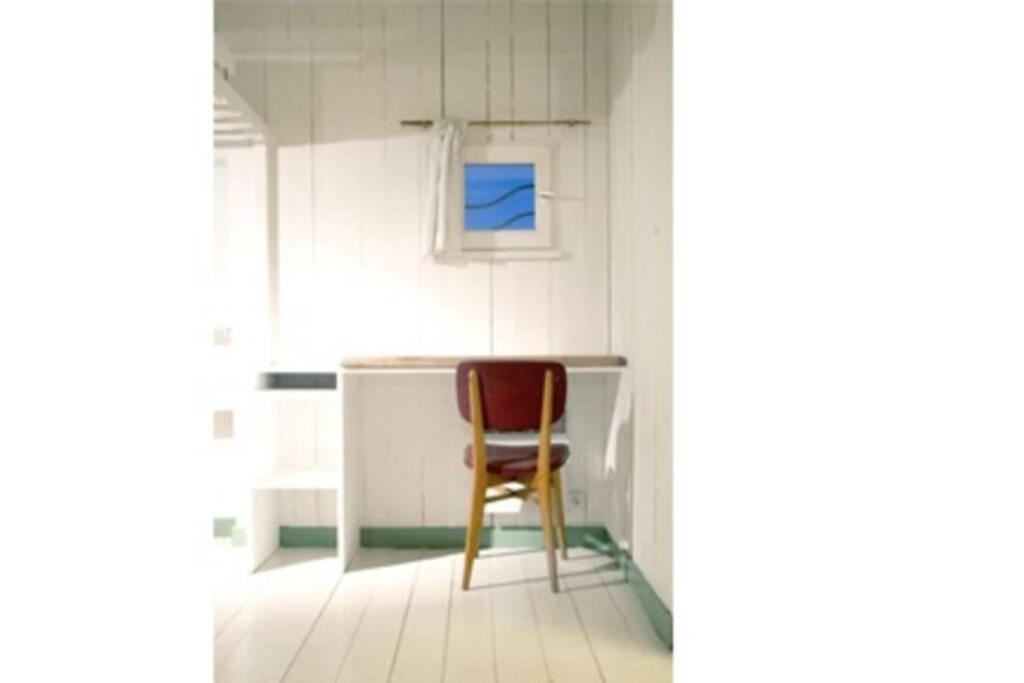 a chair sitting at a desk in a room at Logement Design à Loix-en-Ré - 2 étoiles - Centre Village in Loix