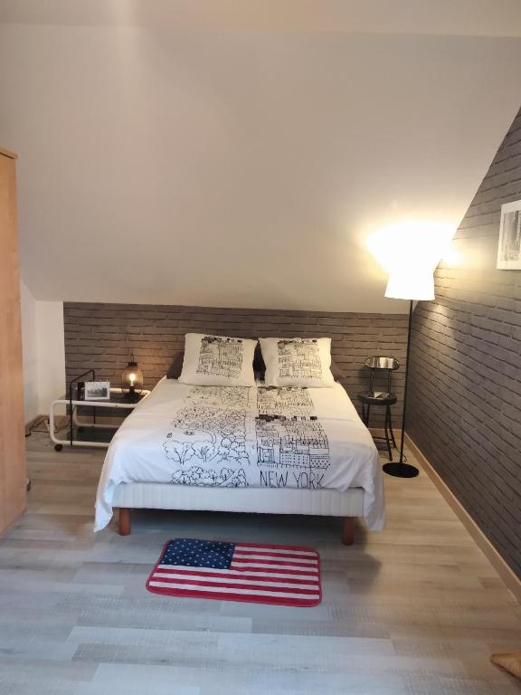 a bedroom with a bed with an american flag on it at Chambre de l'Orée du Bois in Audeux