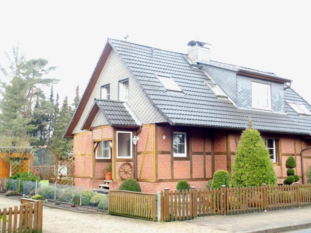 een huis met een houten hek ervoor bij Ferienhaus Heideblüte in Schneverdingen