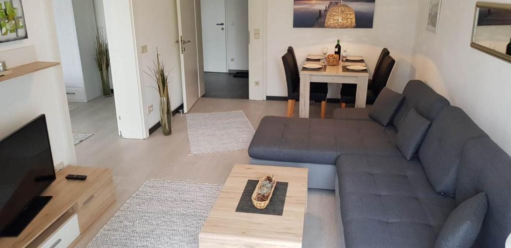 ein Wohnzimmer mit einem Sofa und einem Tisch in der Unterkunft Ambiente Ferienapartments Warmbad Villach in Villach