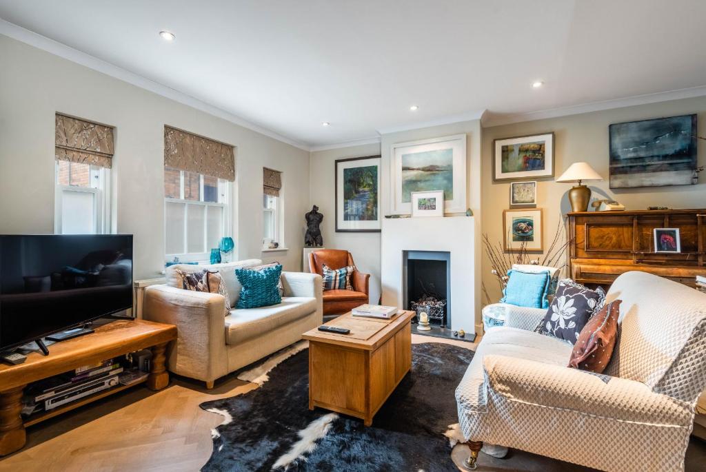 a living room filled with furniture and a tv at Charming Chiswick Home near Ravenscourt Park by UndertheDoormat in London