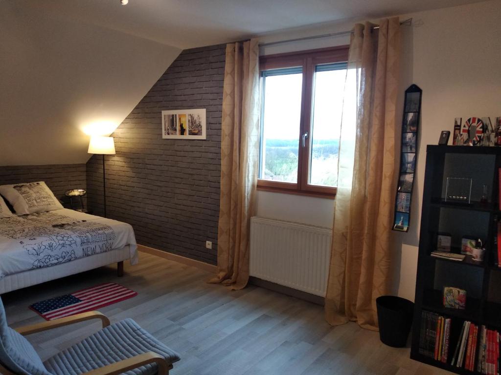 a bedroom with a bed and a large window at Chambre de l'Orée du Bois in Audeux