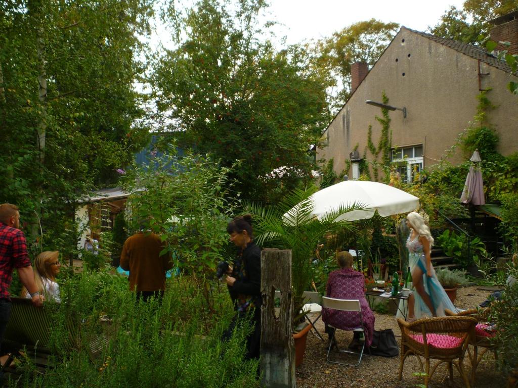eine Gruppe von Menschen, die in einem Garten sitzen in der Unterkunft Haus im grünen - Hürth in Fischenich