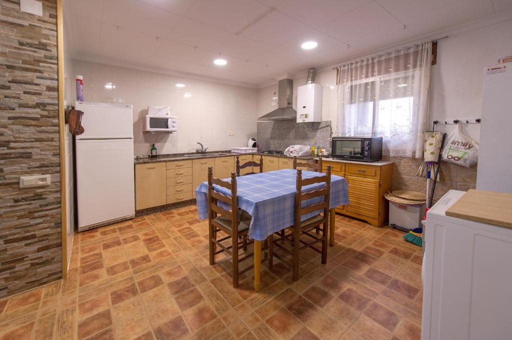 リオパルにあるCasa rural LAS TABLASのキッチン(テーブル、白い冷蔵庫付)