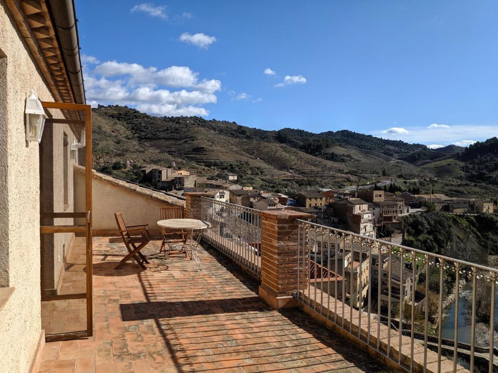 balcón con mesa y vistas a la ciudad en L'Acadèmia de La Vilella Baixa 3, en La Vilella Baixa