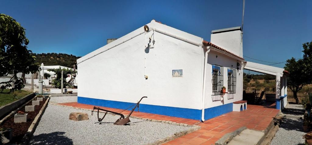a white and blue building with a metal object outside at Monte da Mesquita in Arraiolos