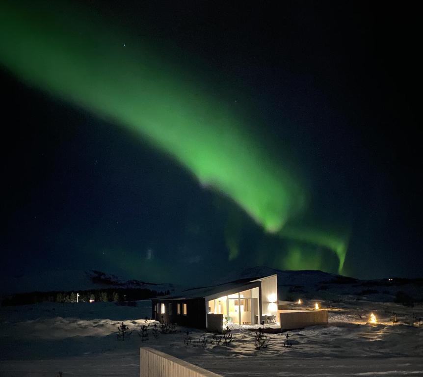 a building with the aurora in the sky at Kerbyggd: Luxury house and cottage in golden circle in Selfoss