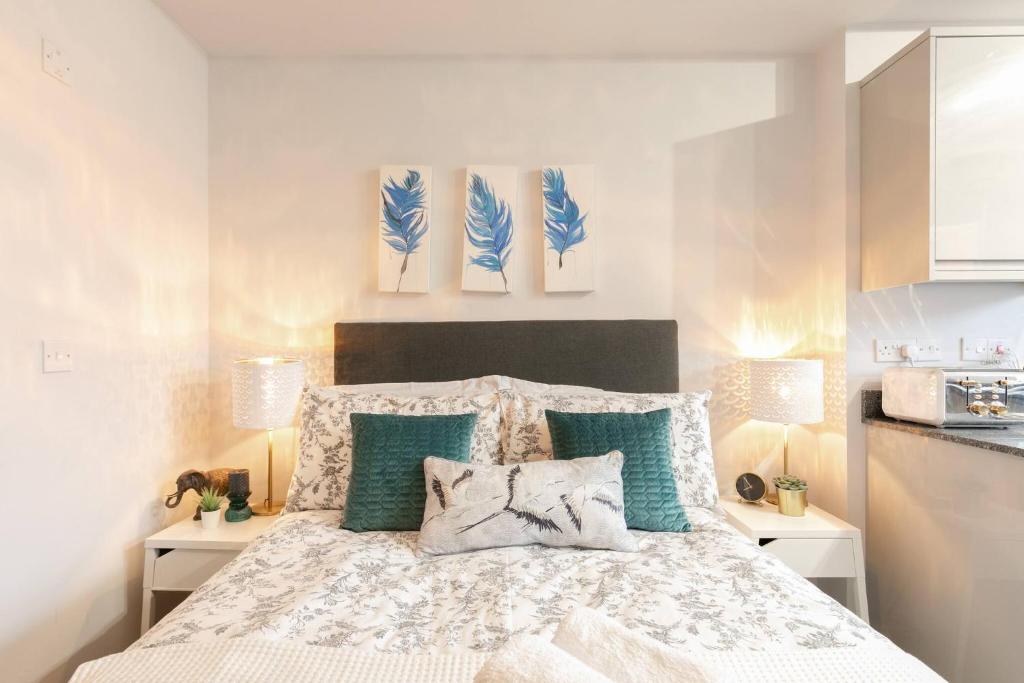 1 dormitorio con 1 cama con almohadas azules y blancas en 12 Helena Luxury Serviced Apartment en Reading