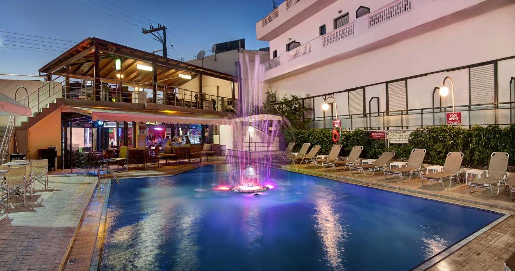 a pool with a fountain in the middle of a building at Ilios 1 Central in Malia
