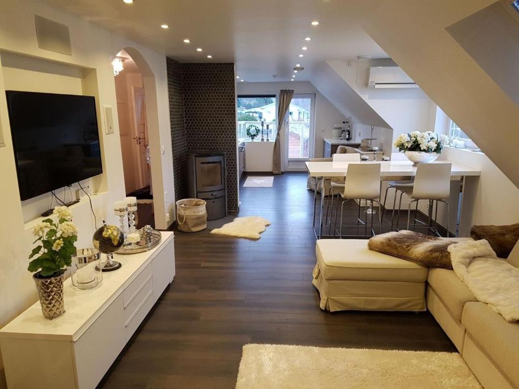uma sala de estar com um sofá e uma mesa com uma televisão em Lagunen Apartments em Bergen