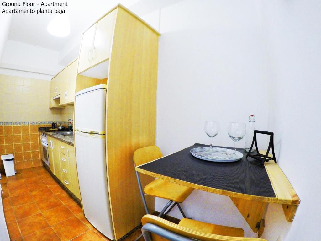 a kitchen with a table with two wine glasses on it at Apartamentos Ester in Santa Cruz de Tenerife