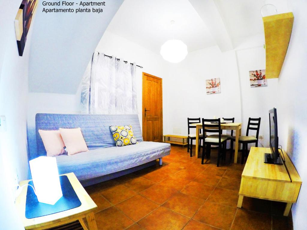 a living room with a blue couch and a table at Apartamentos Ester in Santa Cruz de Tenerife