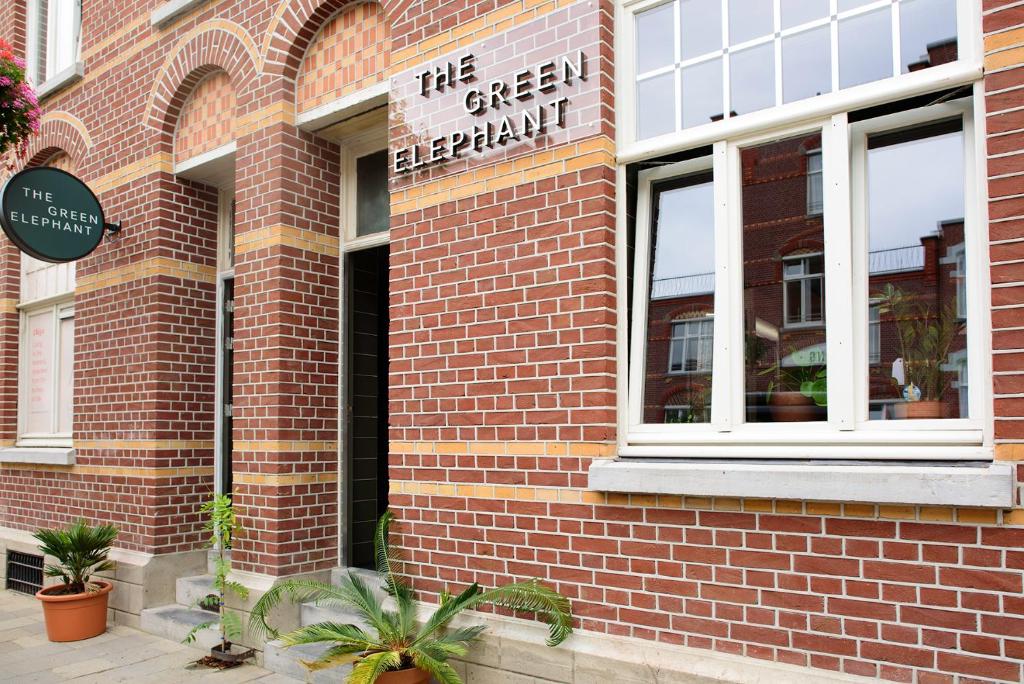 a brick building with a sign on the side of it at The Green Elephant Hostel & Spa in Maastricht