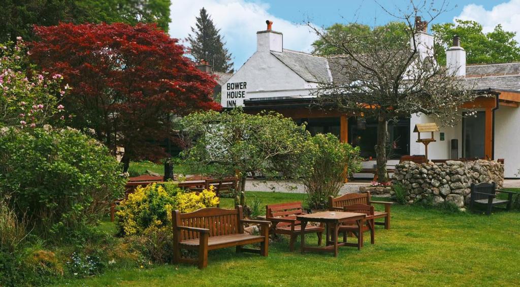 a group of benches sitting in the grass in front of a building at Bower House Inn in Eskdale
