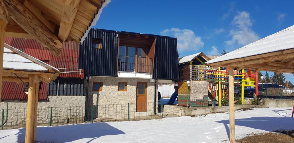 um edifício com um parque infantil na neve em Apartman za dvoje em Travnik