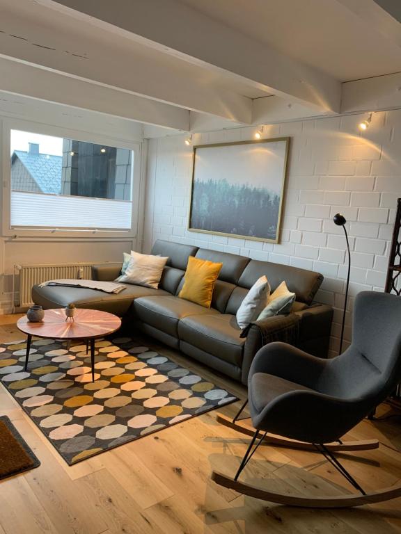 a living room with a couch and a table at Ferienwohnung Mountainlook in Hohegeiß
