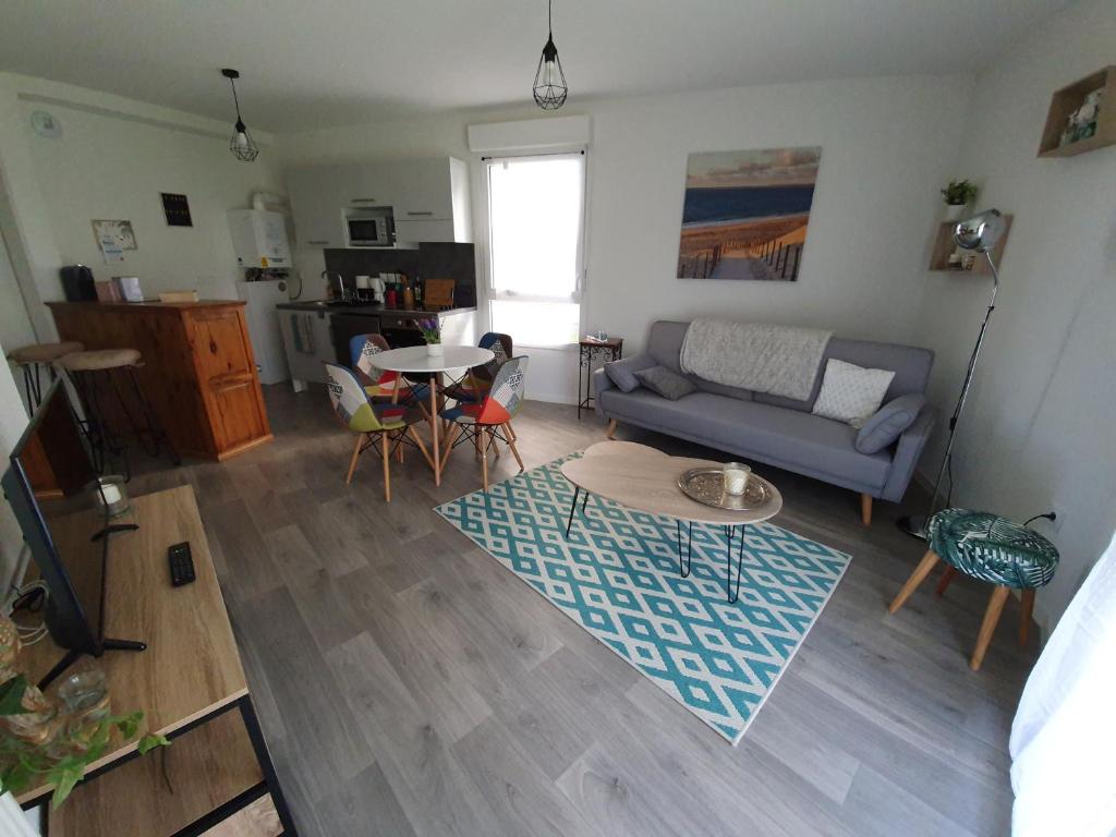 a living room with a couch and a table at L'accalmie Audenge in Audenge