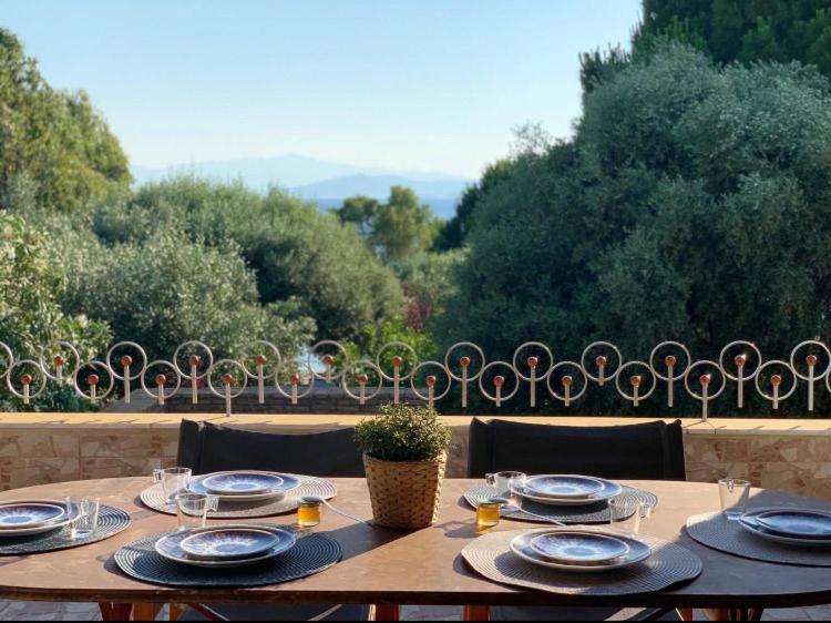 a wooden table with plates and dishes on it at Casa Del Mare (South Evia) in Nea Stira