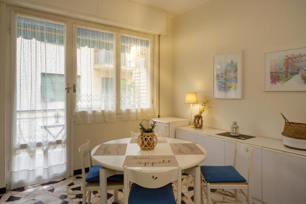 a kitchen with a white table and chairs and windows at Casa Amica in Rapallo