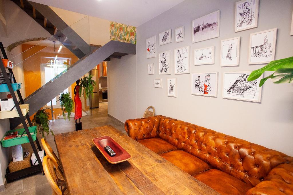 a living room with a leather couch and a table at Lukanda Hospec in Seville