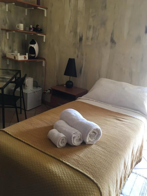 una camera da letto con un letto e asciugamani di B & B La Guesthouse a Poirino