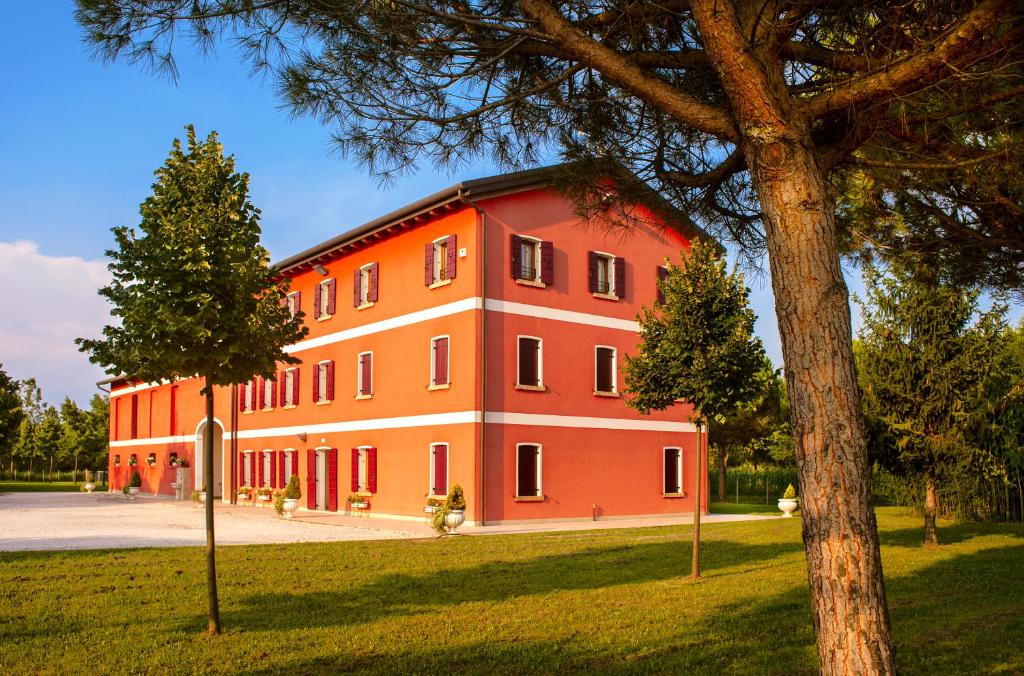 a large red building with a tree in front of it at Agriturismo Fondo Gioconda in Marcon