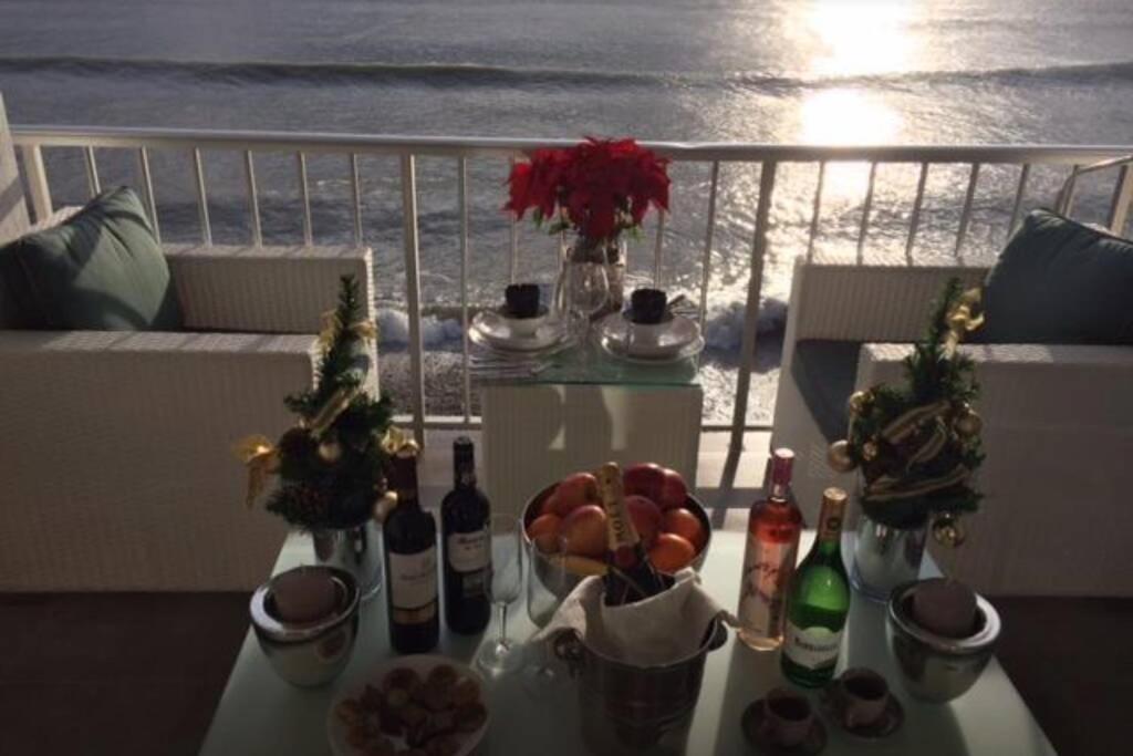 una mesa con botellas de vino y fruta en el balcón en Oden 11, en Altea