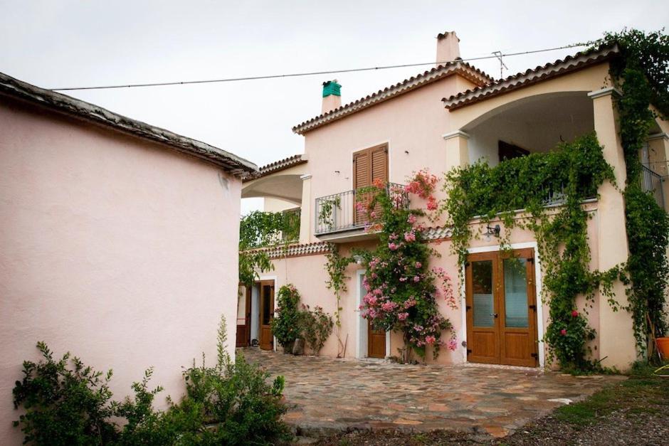 Una casa blanca con hiedra a un lado. en Agriturismo Donnolù, en Tertenìa