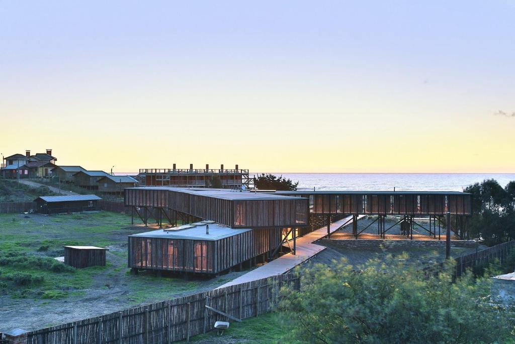 a group of buildings with the ocean in the background at Hotel Punta Sirena in Curanipe