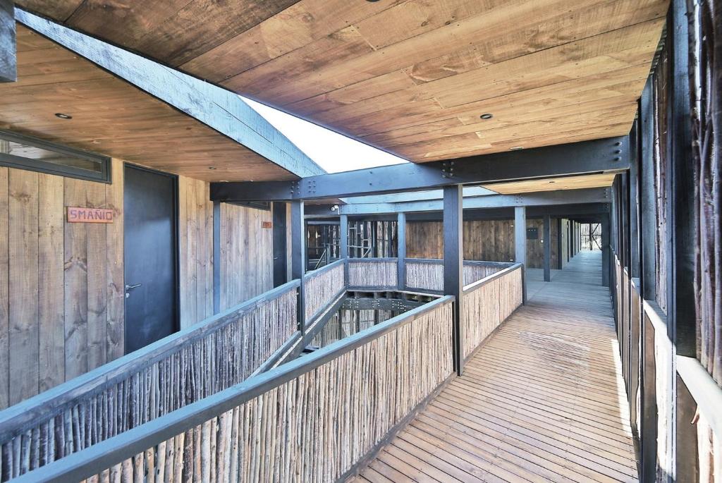 a building with a wooden walkway with a wooden ceiling at Hotel Punta Sirena in Curanipe