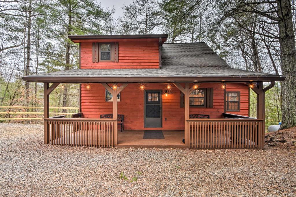 a small red cabin with a large deck at Modern Cabin with Deck in the Blue Ridge Mountains! in Blairsville
