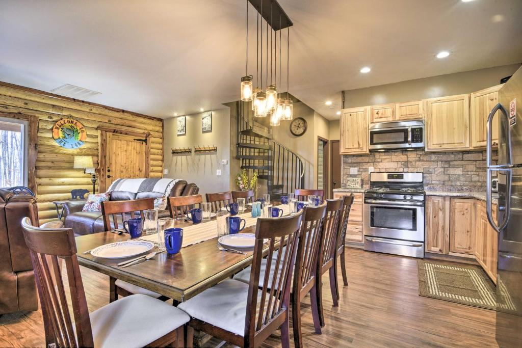 a kitchen and dining room with a table and chairs at Stylish Creekside Cabin with Fire Pit Near Wineries! in Pittsville