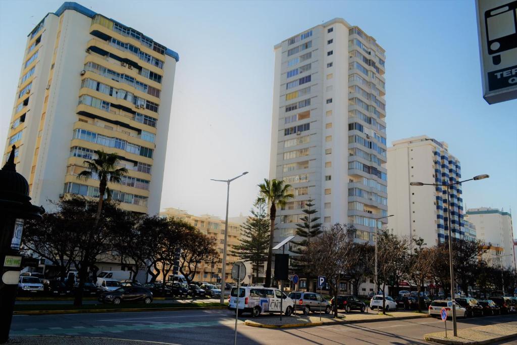 due edifici alti in una strada di città con le auto di Torres Mira Praia by Garvetur a Quarteira