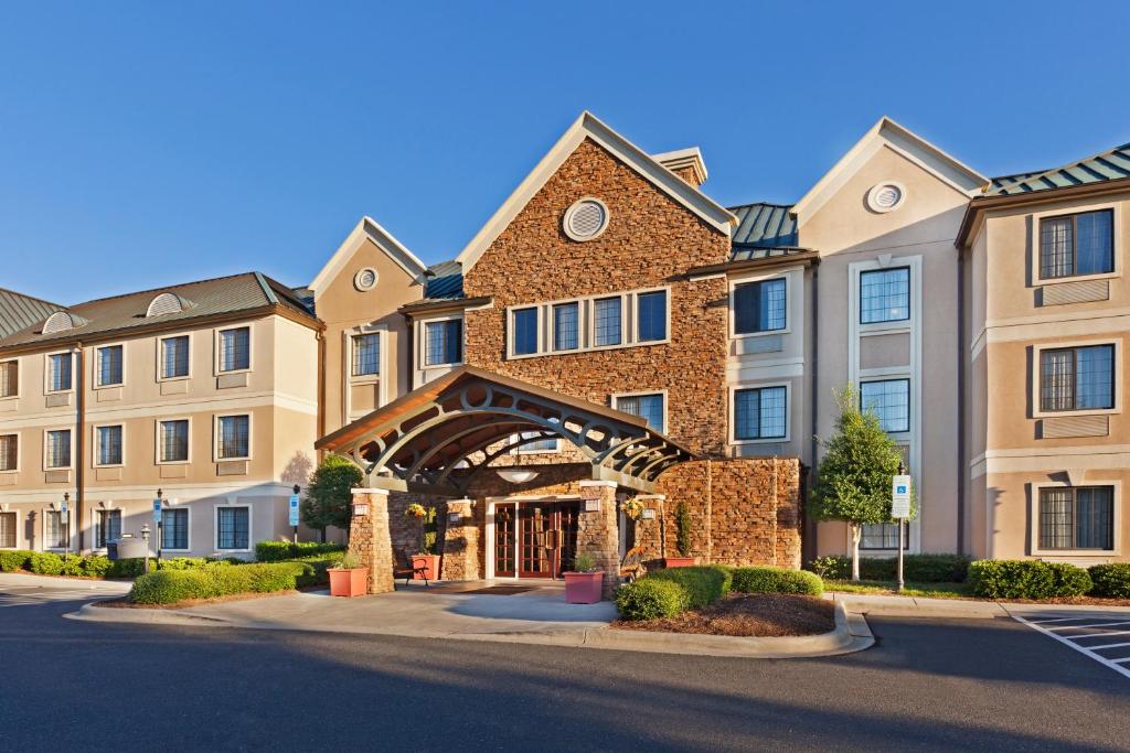 a row of apartment buildings with a building at Staybridge Suites - Charlotte Ballantyne by IHG in Charlotte