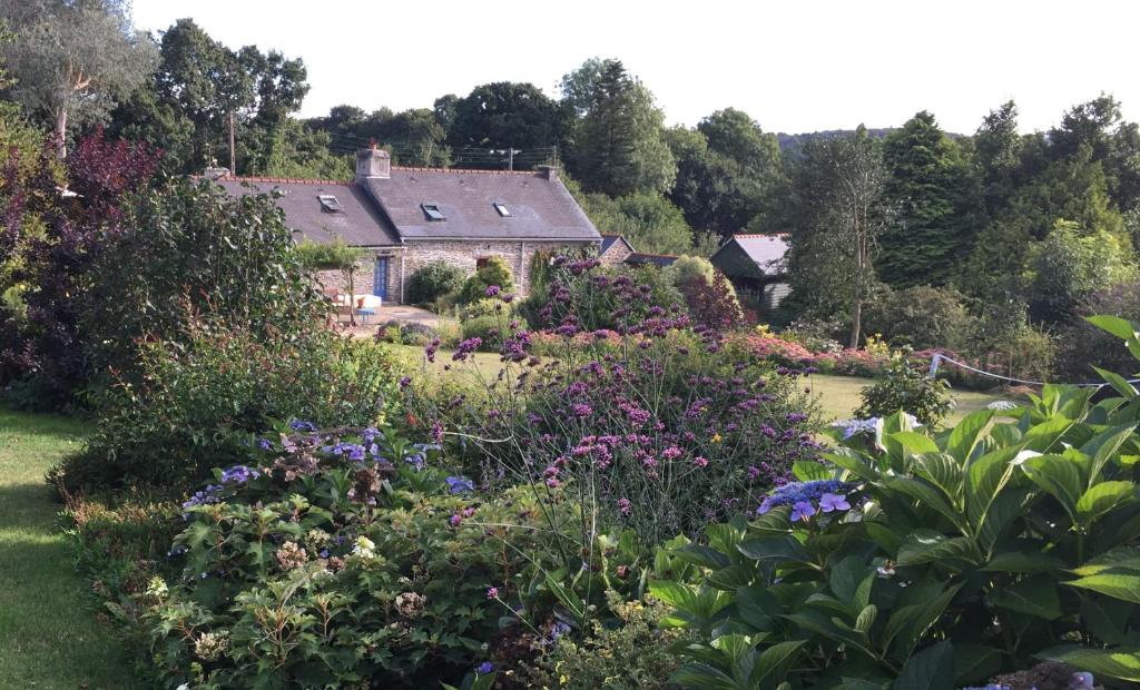 un giardino di fronte a una casa con fiori di Kerlogan a Saint-Thois
