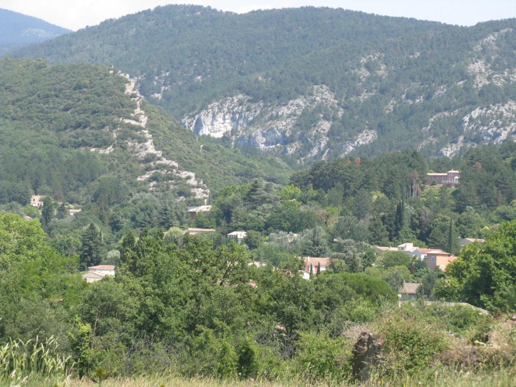 a winding road up a mountain with trees and houses at Maison L'Acanaud in Malaucène