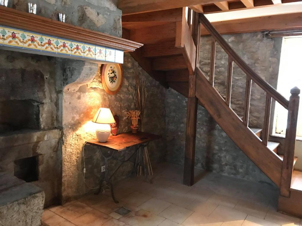 a room with a staircase and a lamp on a table at Morvan La Pastourelle in Quarré-les-Tombes