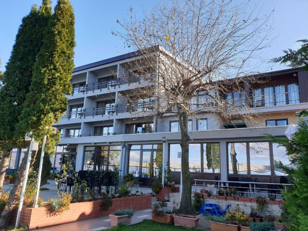 un edificio con un albero di fronte di Hotel Millennium a Pogradec