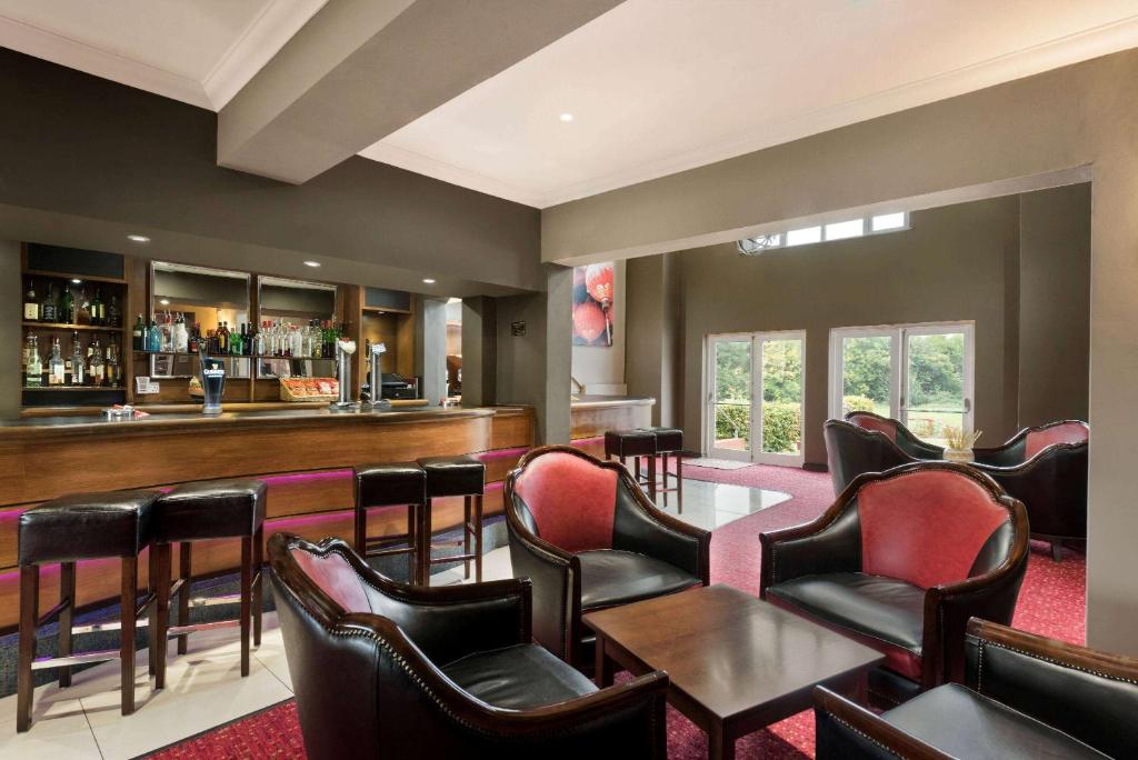 a bar in a restaurant with chairs and a counter at Riverside Hotel in Warwick