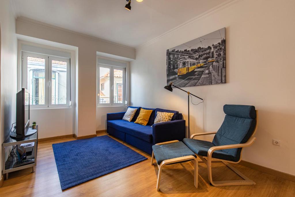 a living room with a blue couch and a tv at 3 bedroom apt near Av. Liberdade in Lisbon