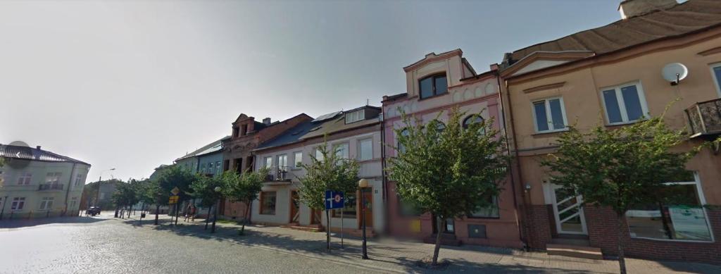 a row of buildings on a street with trees at NOCLEGI U IRENKI in Koło