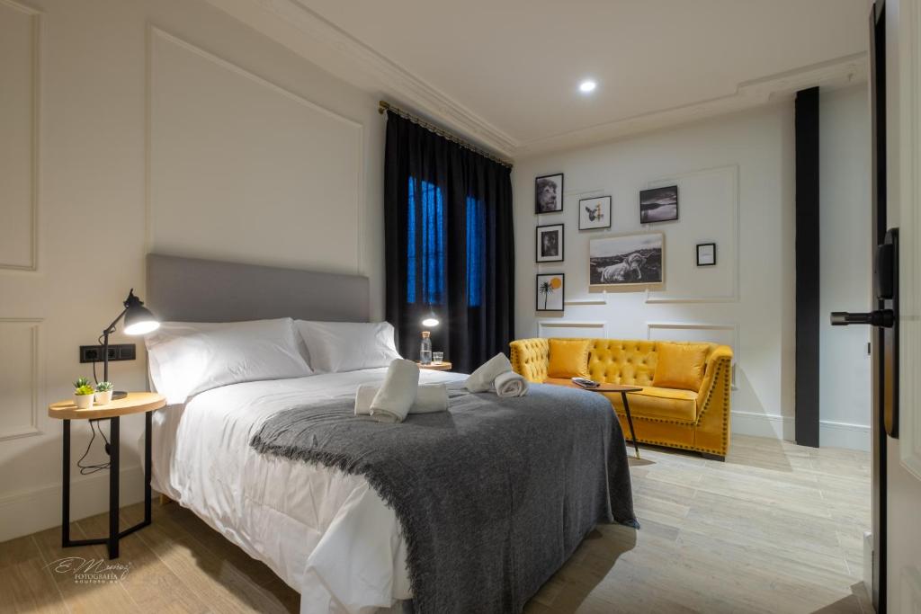sypialnia z łóżkiem, kanapą i krzesłem w obiekcie Barbarossa Suites Plaza de España w Meridzie