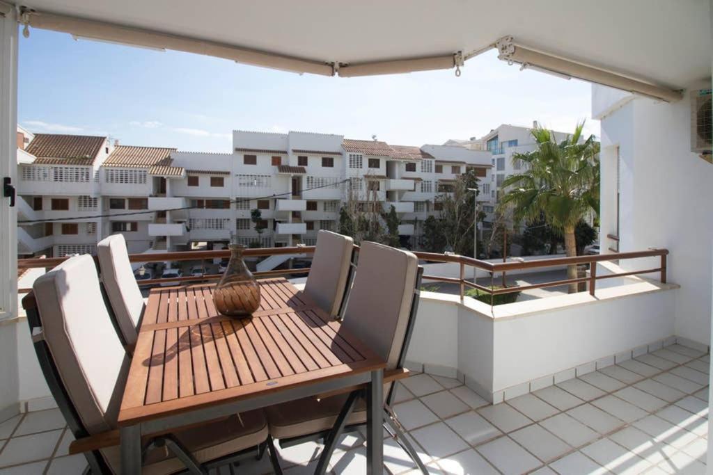 een houten tafel en stoelen op een balkon met uitzicht op de stad bij Santa Elena in Altea